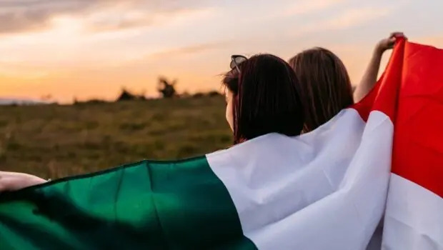 Conservatorismo. Due ragazze con la bandiera italiana e paesaggio rurale sullo sfondo